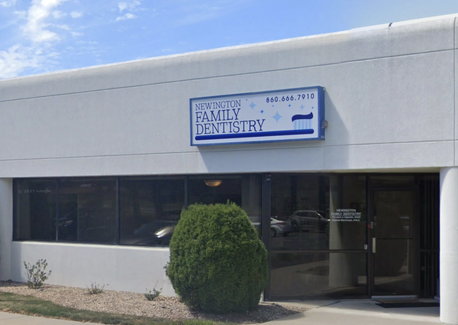 The front of our building with a blue and white sign featuring a large toothbrush